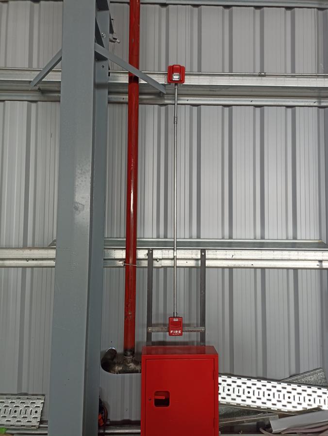 Columna con caño rojo y bandeja en estructura metálica